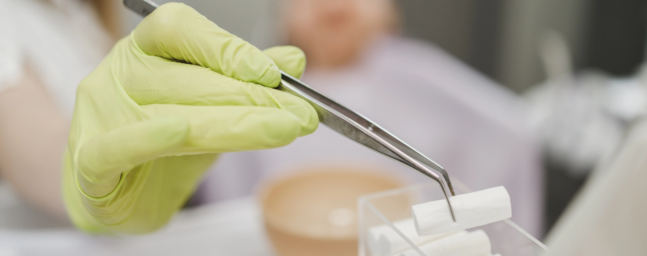 close-up-unrecognisable-dentist-holding-cotton-tampon-during-dental-procedure-dental-clinic